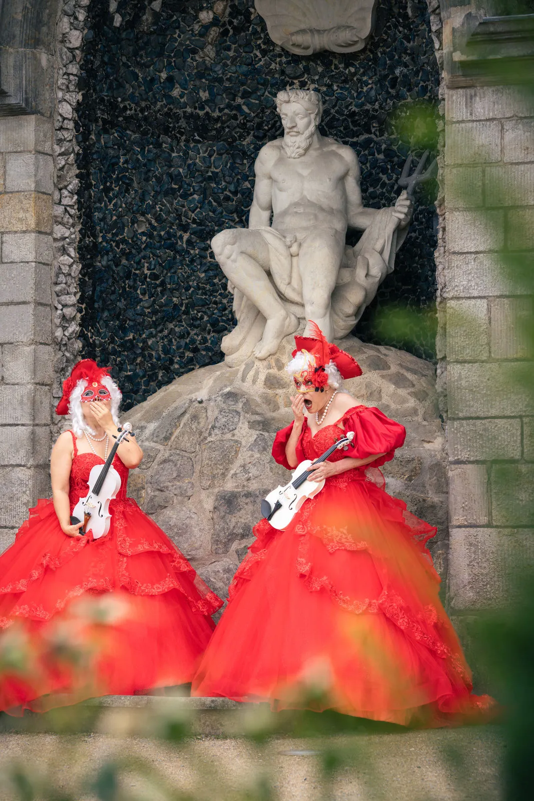 Person in historischer Kleidung spielt Geige auf Treppe.