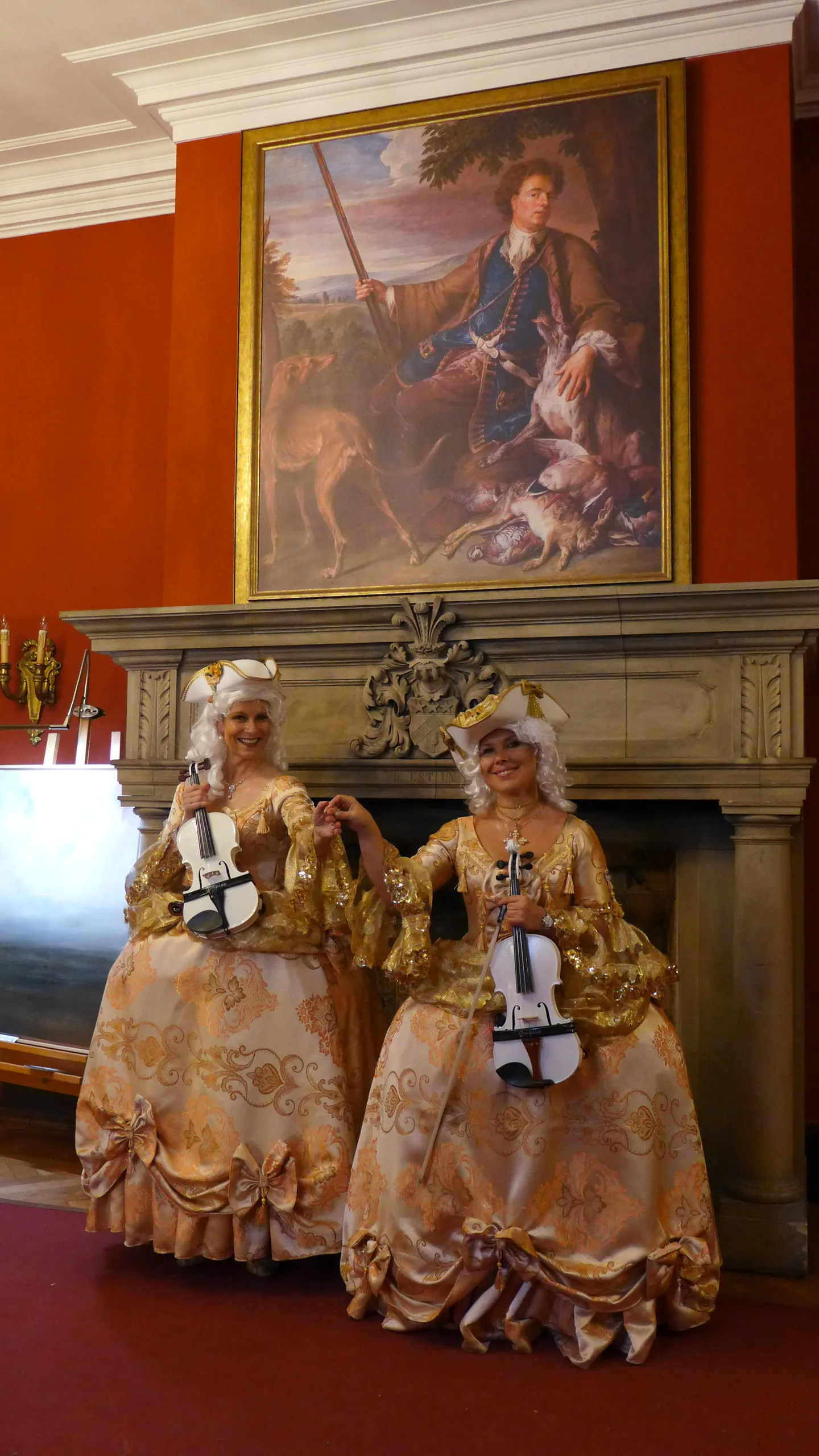 Person in historischer Kleidung spielt Geige auf Treppe.