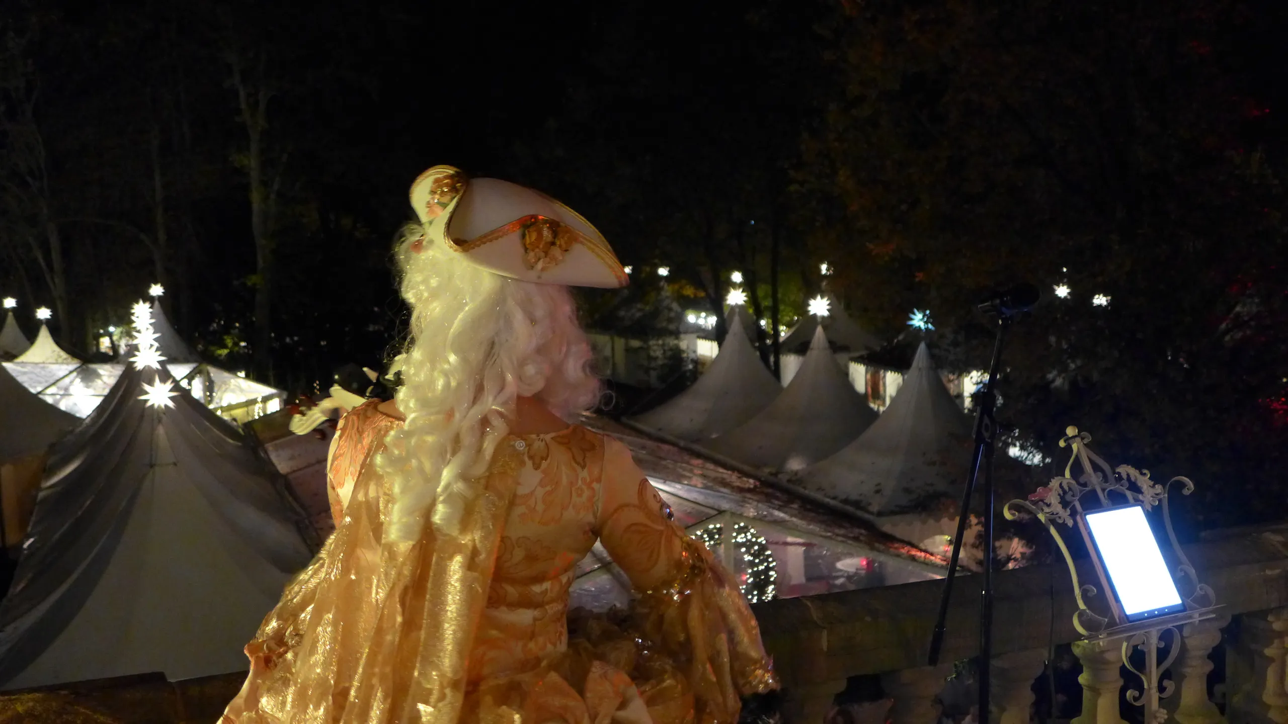 Person in historischer Kleidung spielt Geige auf Treppe.