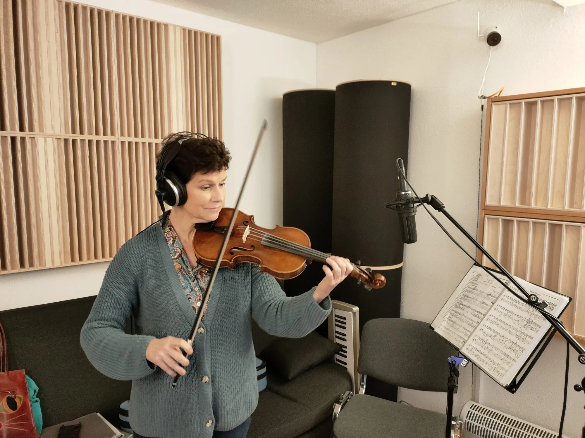 Person in historischer Kleidung spielt Geige auf Treppe.
