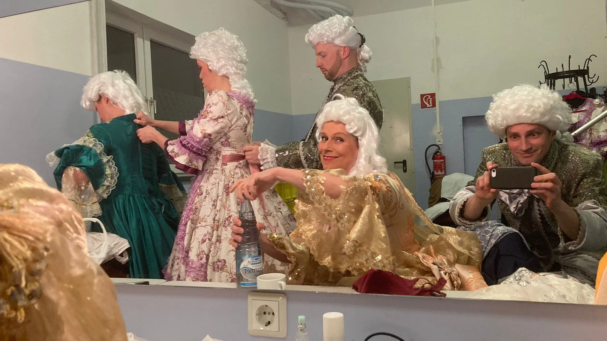 Person in historischer Kleidung spielt Geige auf Treppe.